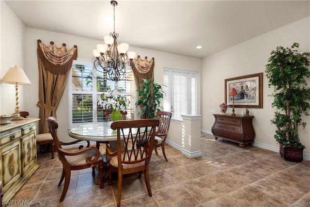 dining area with dark tile patterned flooring and a chandelier