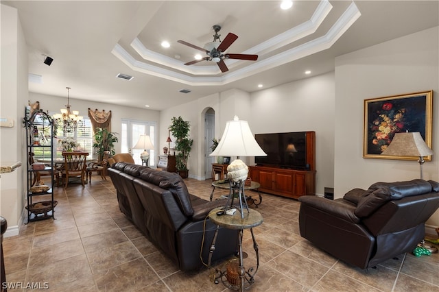 tiled living room featuring ceiling fan with notable chandelier and a tray ceiling