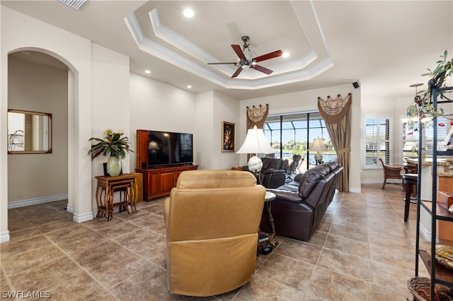 tiled living room featuring a tray ceiling and ceiling fan