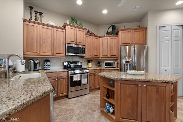 kitchen featuring light tile patterned flooring, tasteful backsplash, a kitchen island, appliances with stainless steel finishes, and sink