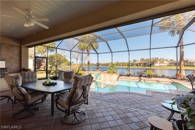 view of swimming pool with a patio area, a water view, a lanai, and ceiling fan