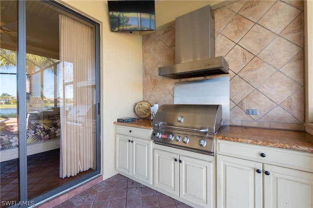 kitchen with dark tile patterned floors, white cabinets, ventilation hood, and stone countertops