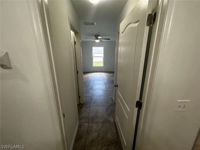 hallway featuring dark tile patterned floors