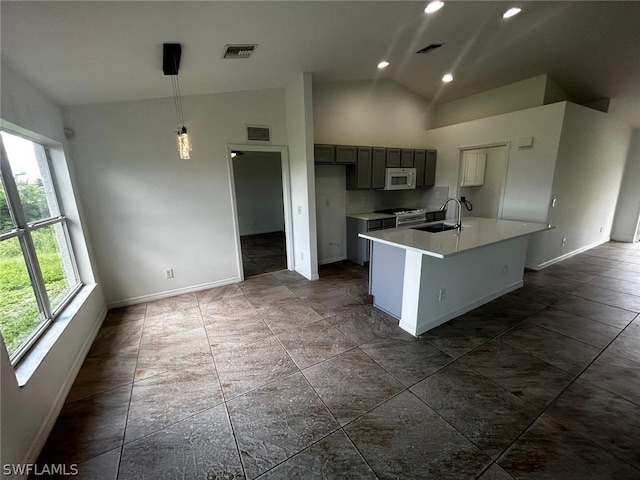 kitchen with gray cabinetry, stainless steel electric range, a center island with sink, sink, and decorative light fixtures