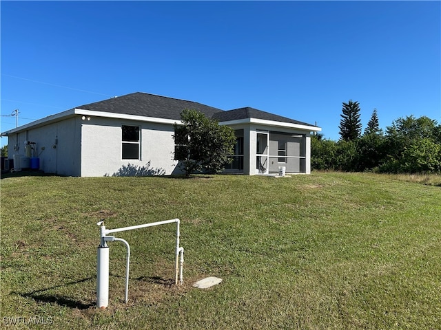 view of front facade featuring a sunroom and a front lawn