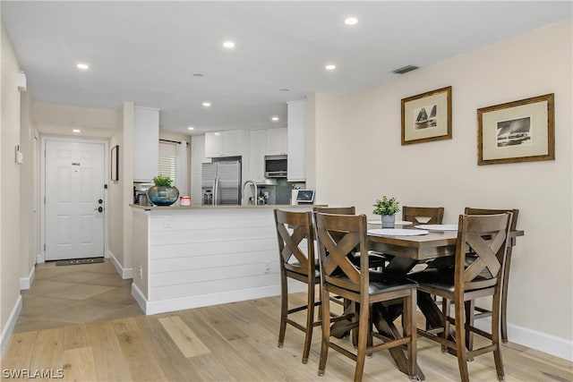 dining area featuring sink and light hardwood / wood-style flooring