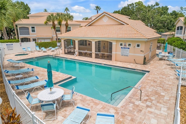 view of pool with a sunroom and a patio area