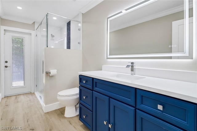 bathroom featuring hardwood / wood-style floors, vanity, crown molding, toilet, and walk in shower