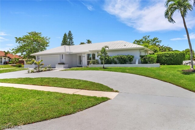 ranch-style house featuring a front yard and a garage