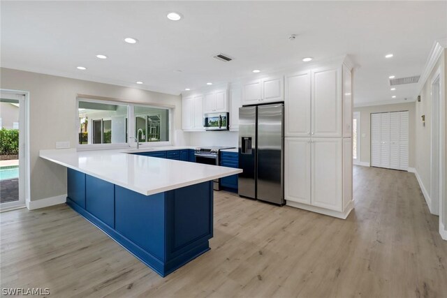 kitchen with kitchen peninsula, white cabinets, light wood-type flooring, and appliances with stainless steel finishes