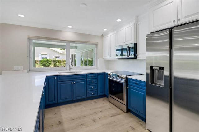 kitchen featuring white cabinets, blue cabinets, sink, appliances with stainless steel finishes, and light hardwood / wood-style floors