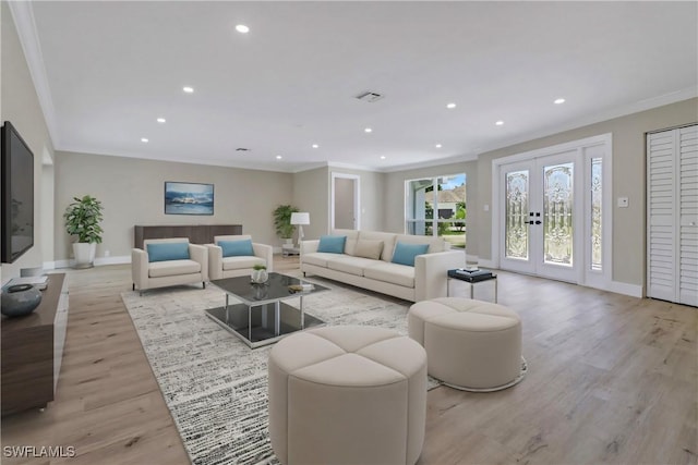 living room featuring light hardwood / wood-style floors, crown molding, and french doors