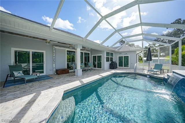 outdoor pool featuring a lanai, ceiling fan, fence, and a patio