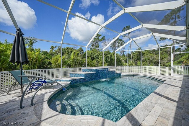 view of pool with an in ground hot tub, pool water feature, a patio, and a lanai