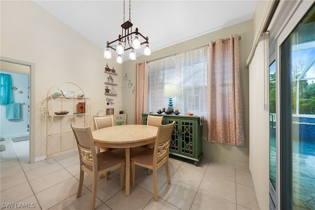 tiled dining room featuring an inviting chandelier and lofted ceiling