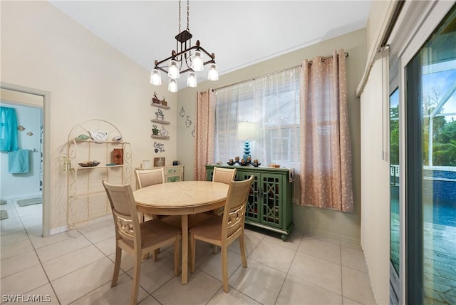 dining room featuring light tile patterned floors, baseboards, a chandelier, and vaulted ceiling