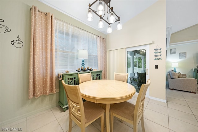 dining area with light tile patterned floors, crown molding, and a chandelier