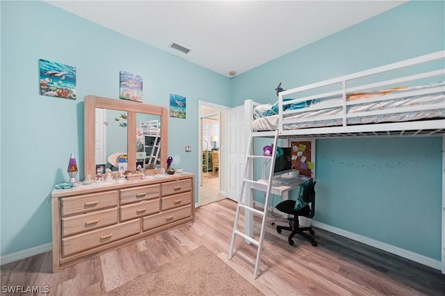 bedroom featuring light wood finished floors, visible vents, and baseboards