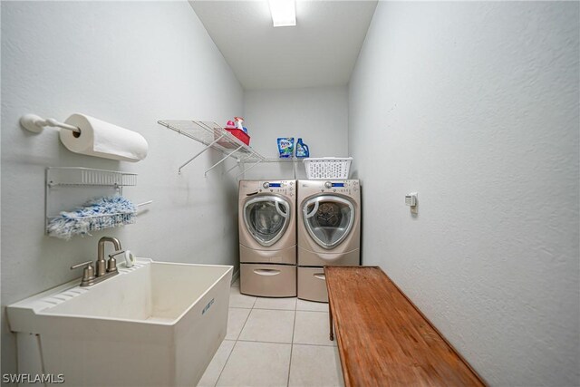 laundry area with sink, light tile patterned flooring, and washer and dryer