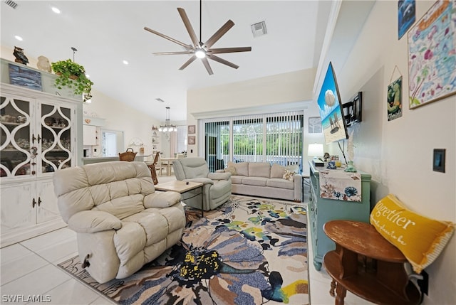 tiled living room featuring lofted ceiling and ceiling fan with notable chandelier