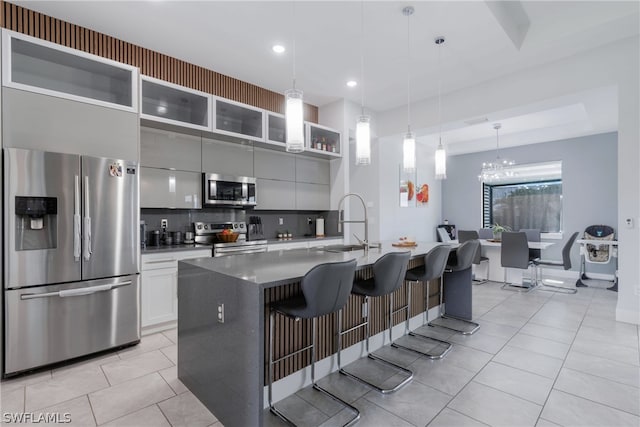 kitchen featuring a breakfast bar, tasteful backsplash, appliances with stainless steel finishes, sink, and gray cabinetry