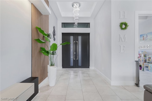 tiled entryway featuring a tray ceiling