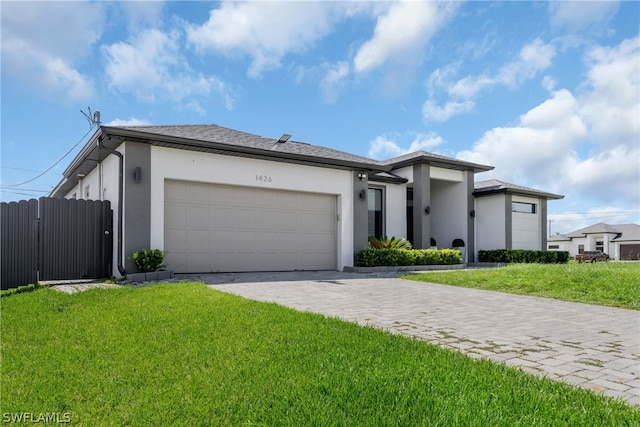 view of front of property with a garage and a front lawn