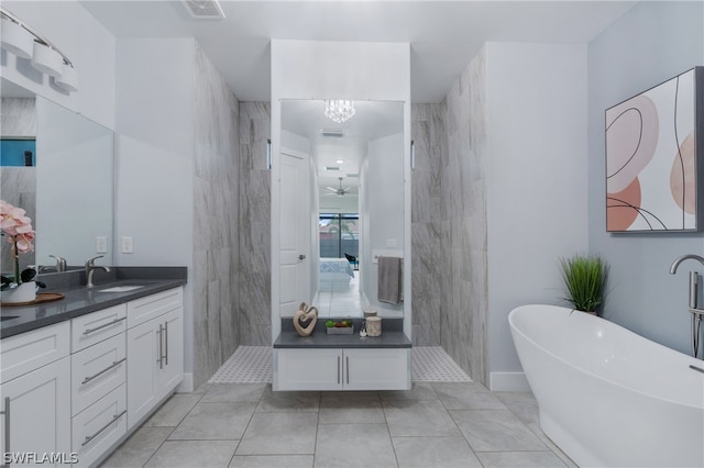 bathroom featuring tile patterned flooring, tile walls, a bathtub, vanity, and ceiling fan