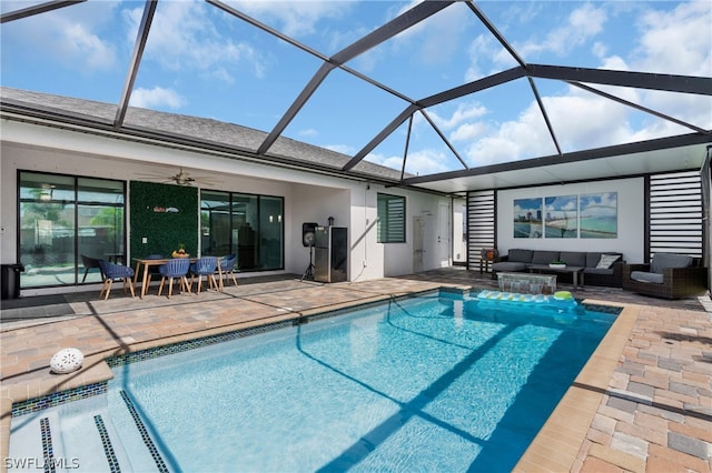 view of swimming pool featuring an outdoor living space, a patio area, ceiling fan, and glass enclosure