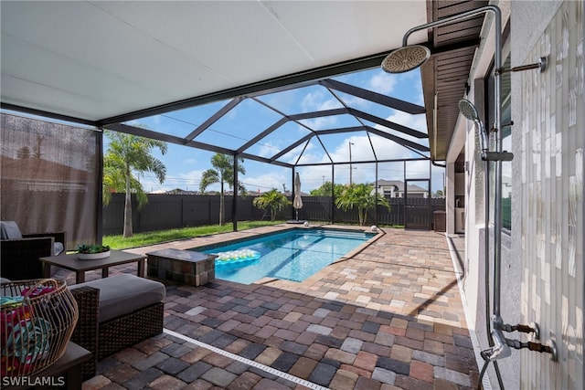 view of swimming pool featuring a patio area and glass enclosure