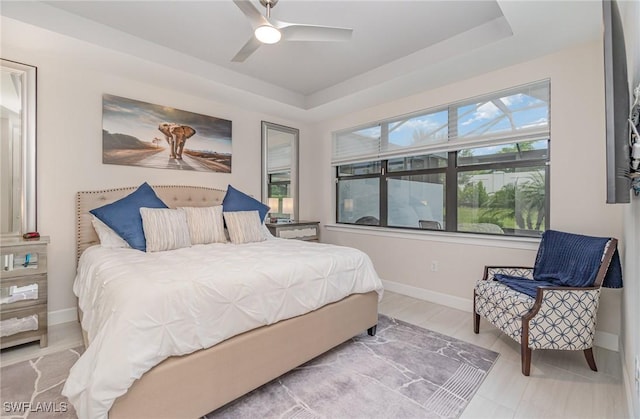 bedroom with ceiling fan and a tray ceiling