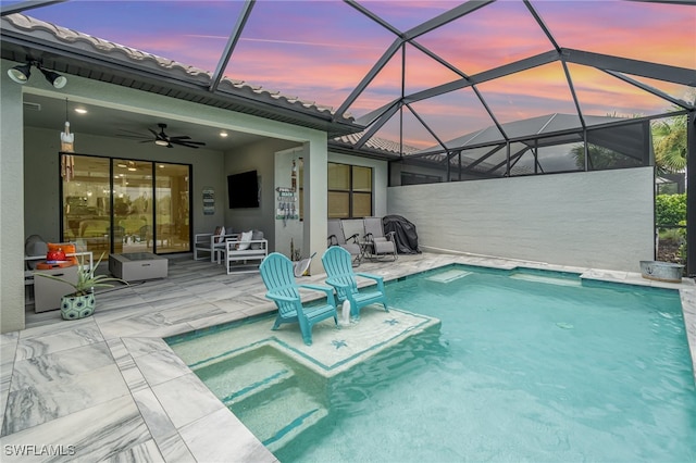 pool at dusk with a patio, ceiling fan, and glass enclosure