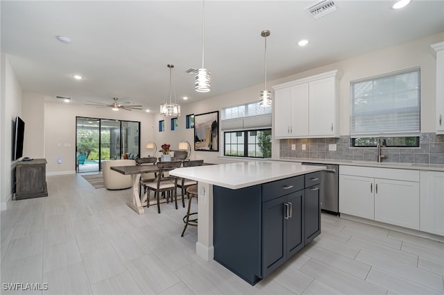 kitchen with sink, pendant lighting, backsplash, a center island, and white cabinetry