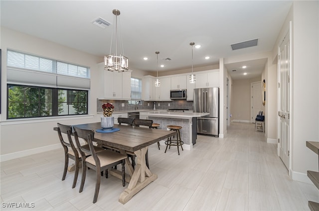 dining space with light tile patterned floors and a chandelier