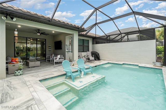 view of swimming pool with glass enclosure, a patio area, and ceiling fan