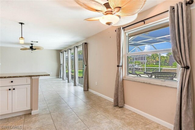 interior space with light tile patterned floors and ceiling fan