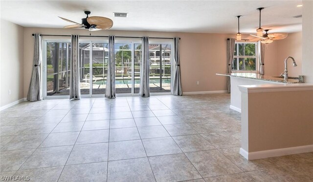 empty room with sink, light tile patterned floors, and ceiling fan