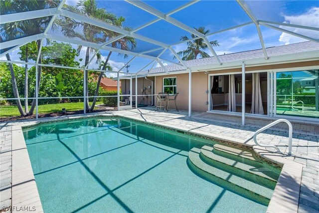 view of swimming pool with a patio and glass enclosure