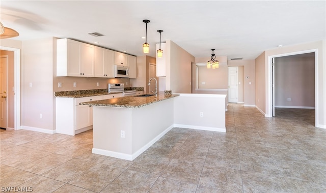 kitchen featuring sink, light tile patterned flooring, range, and pendant lighting