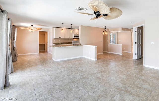 unfurnished living room with sink, ceiling fan, and light tile patterned floors