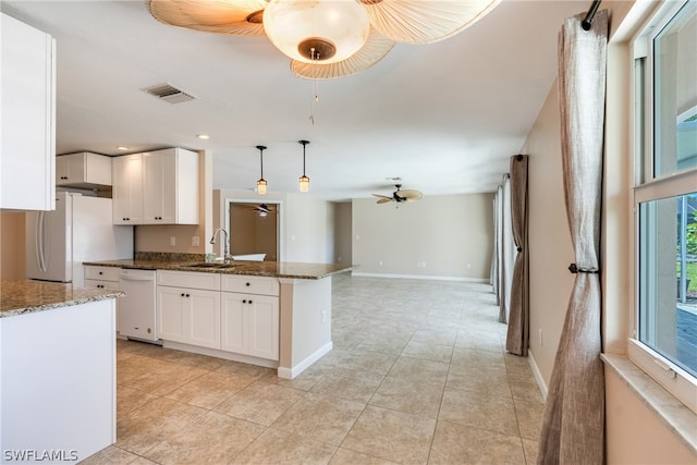 kitchen featuring kitchen peninsula, dark stone counters, ceiling fan, and white appliances