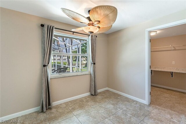 unfurnished bedroom featuring a spacious closet, a closet, ceiling fan, and light tile patterned floors