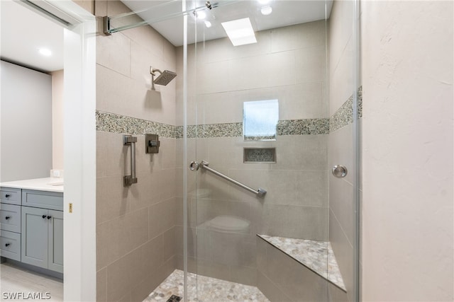 bathroom with a shower with shower door and vanity