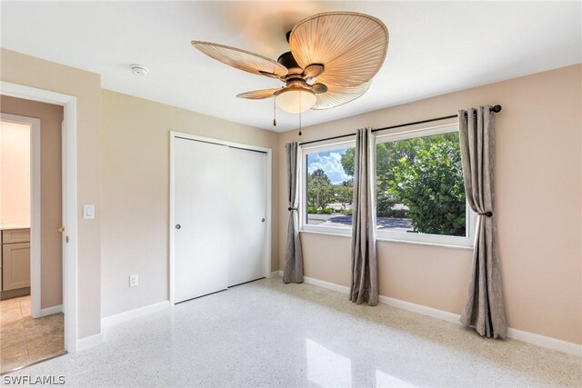 unfurnished bedroom with light tile patterned flooring, a closet, and ceiling fan