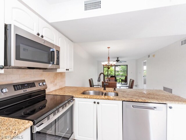 kitchen with white cabinetry, tasteful backsplash, kitchen peninsula, stainless steel appliances, and sink