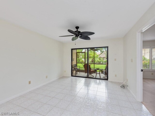 tiled empty room featuring ceiling fan