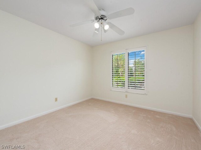 carpeted spare room featuring ceiling fan