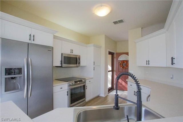 kitchen featuring sink, light hardwood / wood-style flooring, white cabinets, and appliances with stainless steel finishes