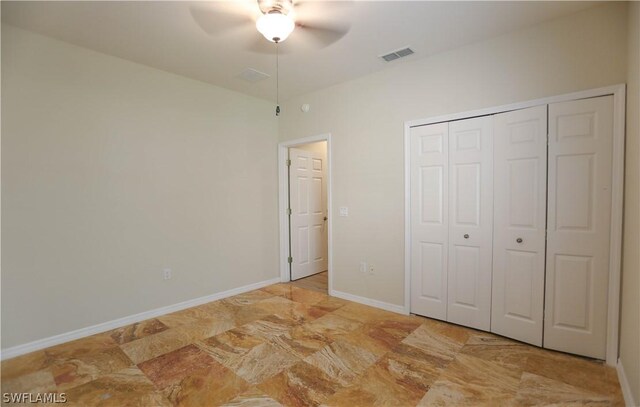 unfurnished bedroom with ceiling fan and a closet