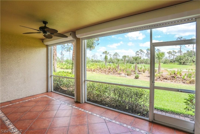 unfurnished sunroom featuring ceiling fan and a healthy amount of sunlight